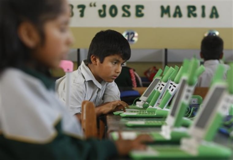 In this June 8, 2012 photo, a boy uses his laptop at the Jose Maria public school in a shantytown on the outskirts of Lima, Peru. 